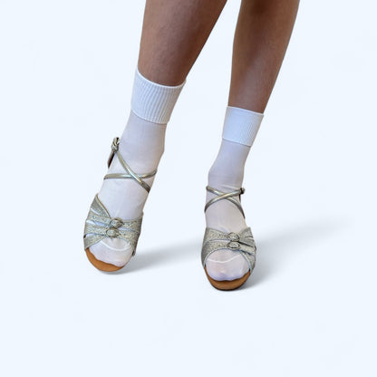 White short ballet socks for kids by International Dance Shoes, worn with glittery dance shoes. Ideal for comfort and style in dance practice.